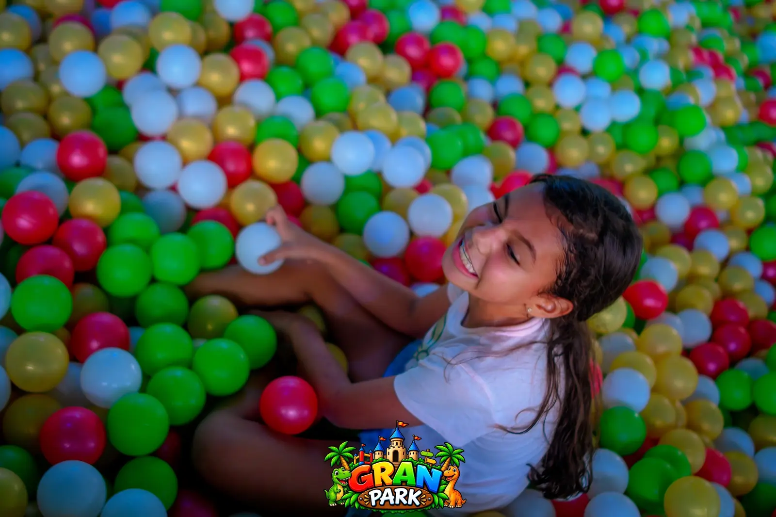 Niña jugando en la piscina de pelotas